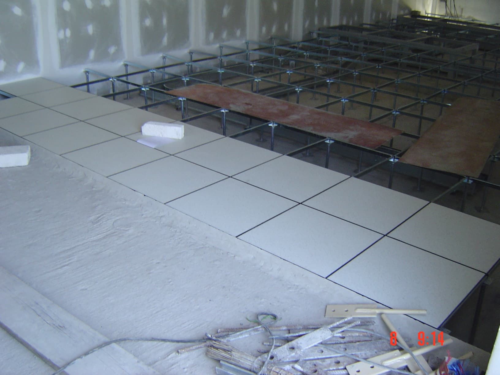 Raised floor installation work in progress, creating an underfloor plenum for efficient cable management and air conditioning in control rooms.