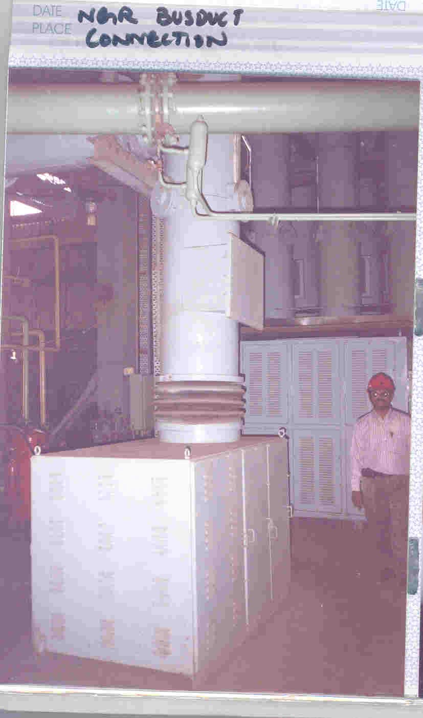 Dense layering of cable trays installed in the ceiling void above a substation control panel room.