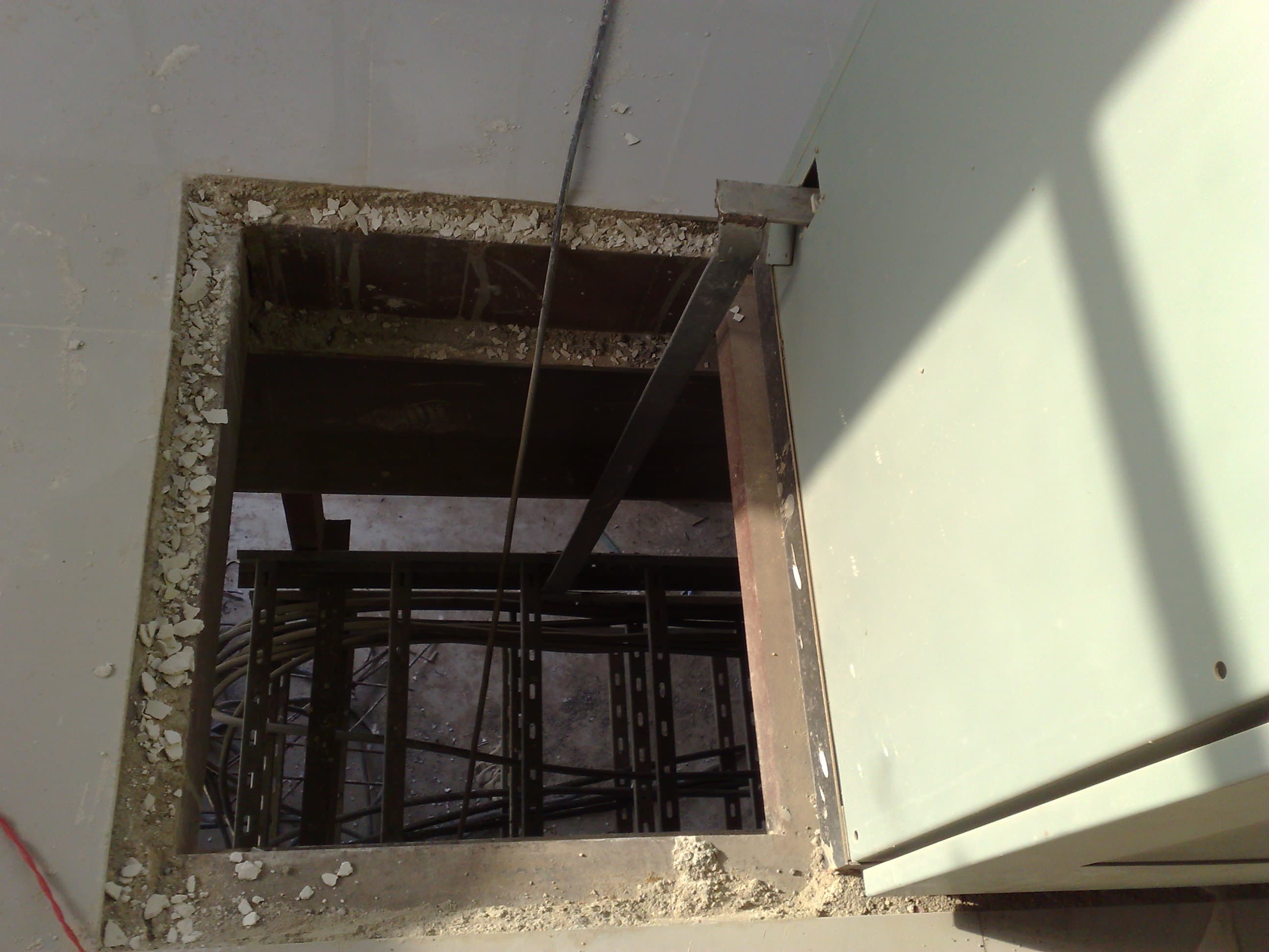 Vertical cable tray raiser routed along a boiler structural column, utilizing existing steelwork for support.